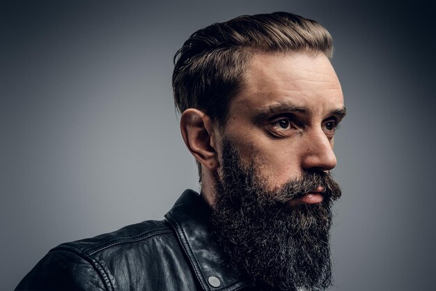 Attractive tired man at photo studio is posing for photographer on the light background.