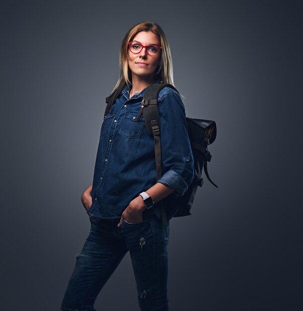 Attractive urban traveler female dressed in a denim shirt and jeans.