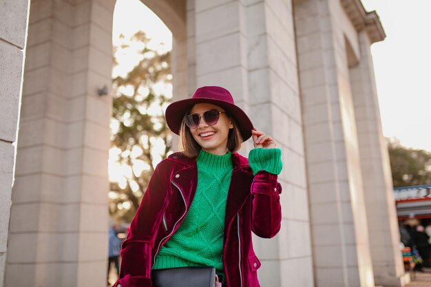 Attractive woman in autumn style trendy outfit walking in street