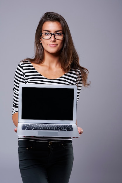 Donna attraente che trasporta un computer portatile