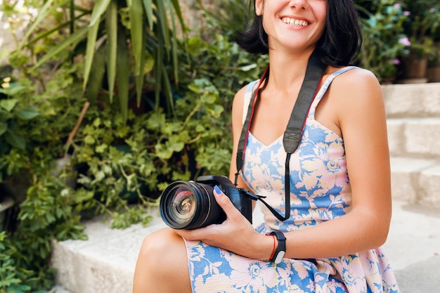 Attractive woman in dress treveling on vacation in Europe by the sea on a cruise taking pictures on camera