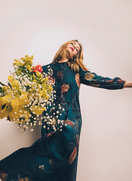 Donna attraente in abito con bouquet di fiori freschi