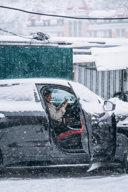 彼女の車のステアリングホイールの後ろに座っている魅力的な女性ドライバー