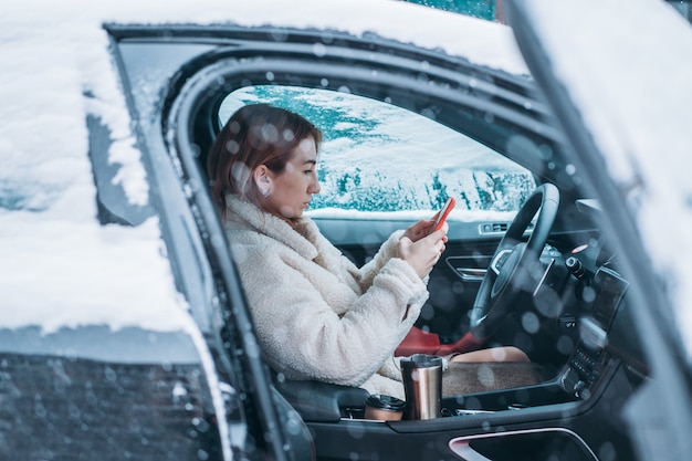 Attractive woman driver sitting behind the steering wheel in her car