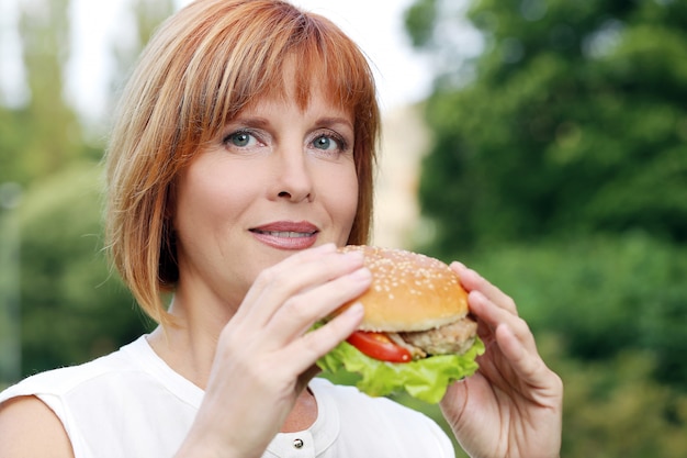 Donna attraente che mangia in un parco