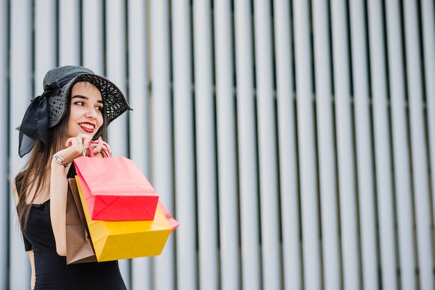 Free photo attractive woman holding colorful bags smiling