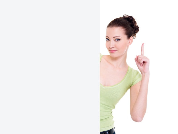 Attractive woman look out from blank banner with lift forefinger up. Idea concept