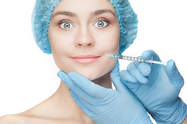 Attractive woman at plastic surgery with syringe in her face on white background