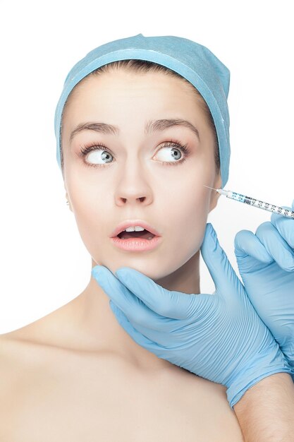 Attractive woman at plastic surgery with syringe in her face