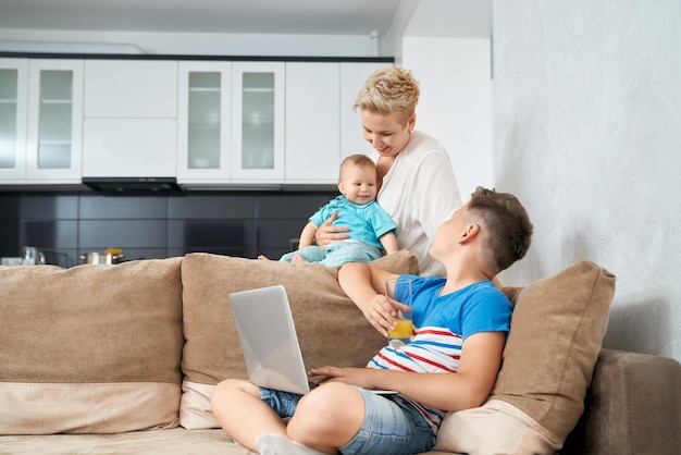 Attractive woman playing with two sons on couch