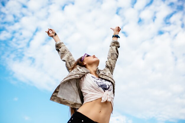 Attractive woman raised her hands up, enjoying perfect day, freedom