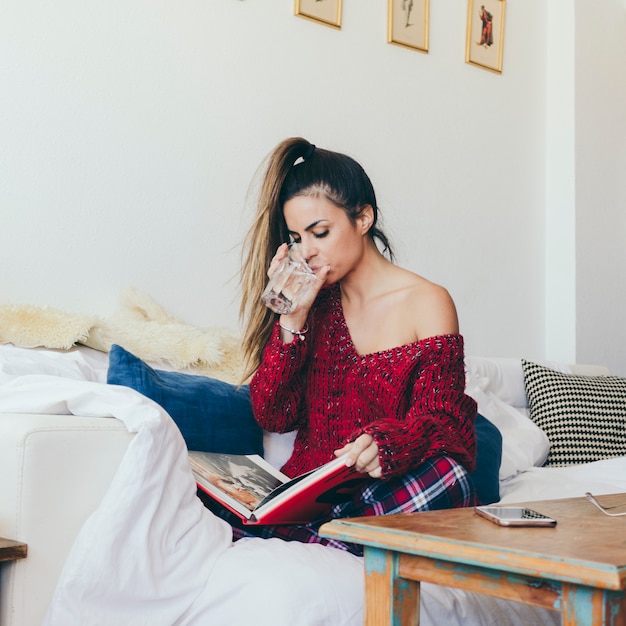 Attractive woman reading and drinking