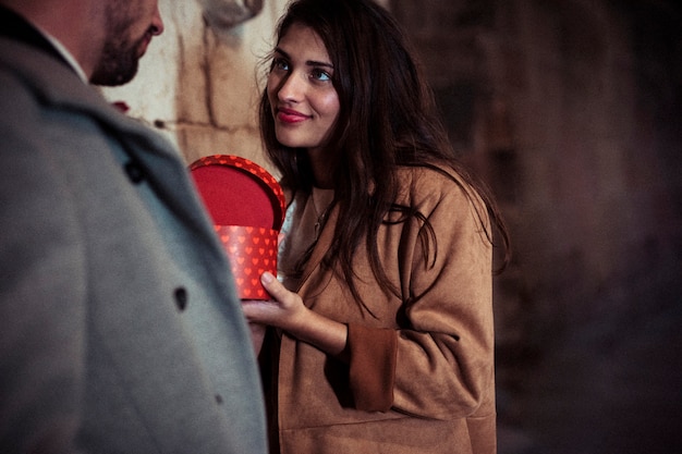 Foto gratuita donna attraente che mostra casella attuale per uomo