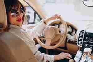 Free photo attractive woman sitting in her car