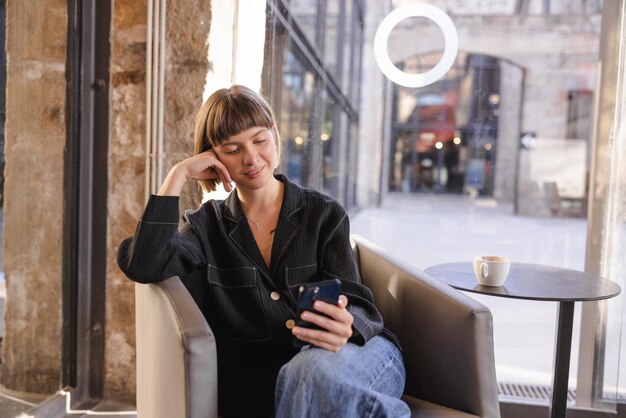 カフェで電話で笑っている魅力的な女性