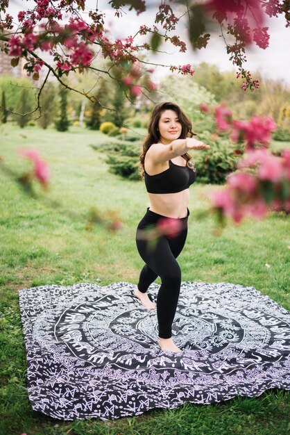 Attractive woman stretching her arms during exercise in park