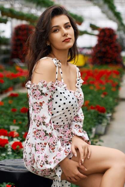 Attractive woman in stylish dress posing at orangery