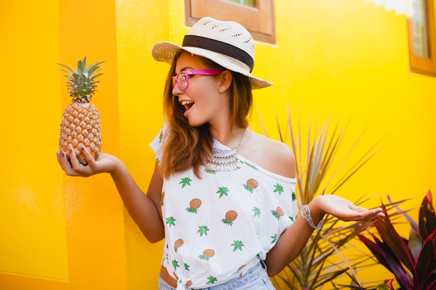 Free photo attractive woman on summer vacation with funny face expression smiling emotional wearing straw hat sitting barefoot surprised