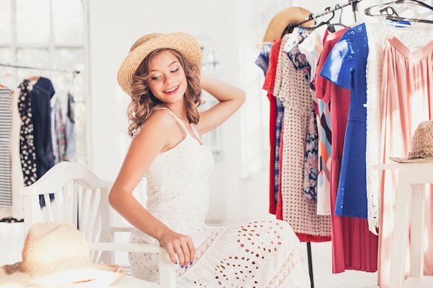 Attractive woman trying on a hat. Happy summer shopping.