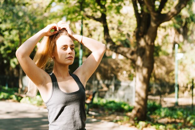 Attractive woman tying ponytail