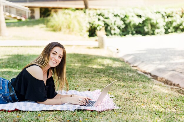 Attractive woman using laptop in park