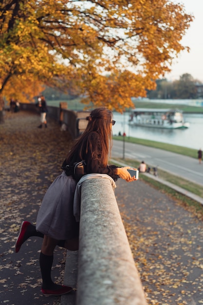 公園で屋外のスマートフォンを使用して魅力的な女性