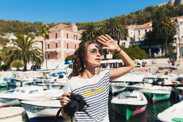 Attractive woman on vacation in Europe by the sea on a cruise taking pictures on camera