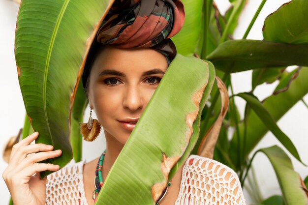 Attractive woman wearing a colorful headscarf like a turban and big round earrings