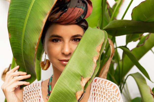 Attractive woman wearing a colorful headscarf like a turban and big round earrings