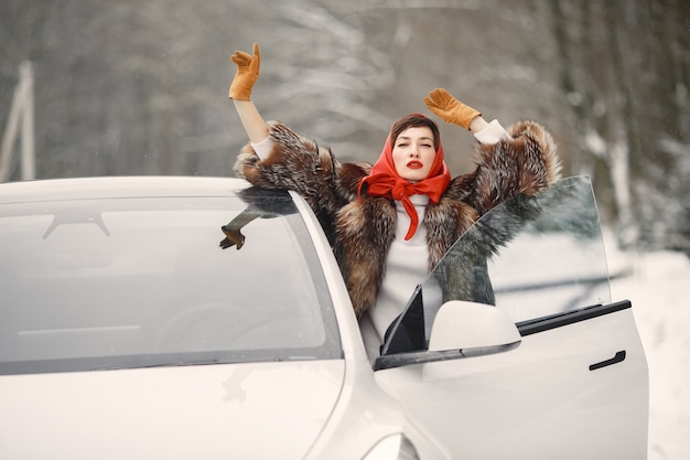 白い車で冬の屋外で魅力的な女性