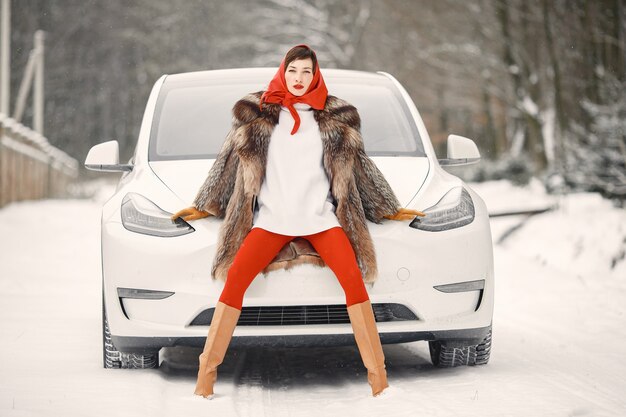 白い車で冬の屋外で魅力的な女性