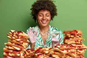 Free photo attractive woman with afro hair surrounded by peanut butter jellly sandwiches