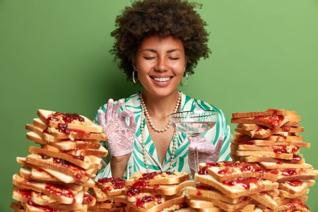 Attractive woman with Afro hair surrounded by peanut butter jellly sandwiches