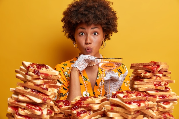 Free photo attractive woman with afro hair surrounded by peanut butter jellly sandwiches