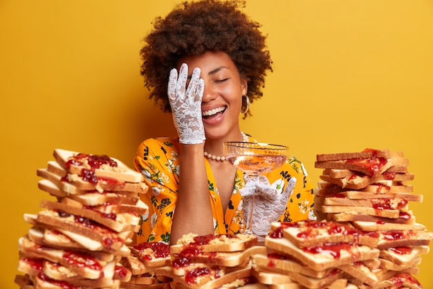 Attractive woman with Afro hair surrounded by peanut butter jellly sandwiches