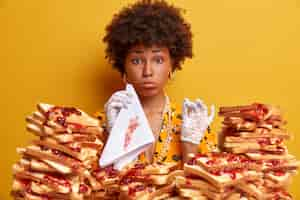 Free photo attractive woman with afro hair surrounded by peanut butter jellly sandwiches