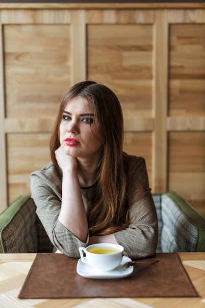 コーヒーカップを持つ魅力的な女性