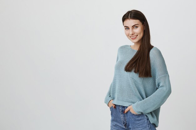 Attractive woman with dark hair, smiling satisfied