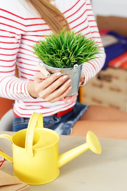 植木鉢と草を持つ魅力的な女性