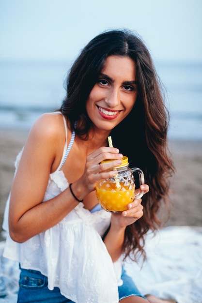 Free photo attractive woman with tropical drink at the beach