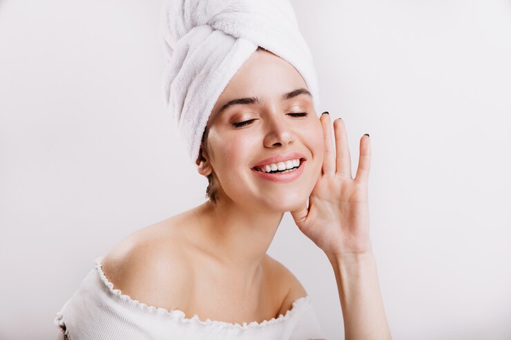 Free Photo attractive woman without makeup posing on white wall. shot of brunette in towel on her head.