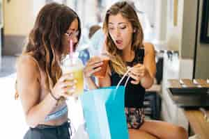 Free photo attractive women examining their purchases