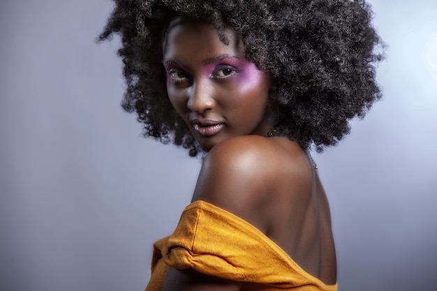 Привлекательная молодая афро-американская женщина с гладкой кожей с красивым макияжем