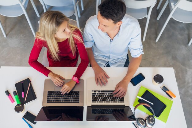 Attractive young attractive people working together online in open space co-working office room