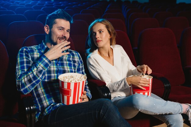 영화 극장, 집 또는 영화관에서 영화를보고 매력적인 젊은 백인 부부.