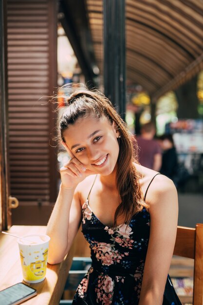 Attractive young caucasian woman sitting in street cafe