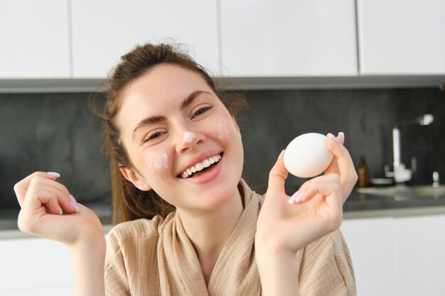 Free photo attractive young cheerful girl baking at the kitchen making dough holding recipe book having ideas