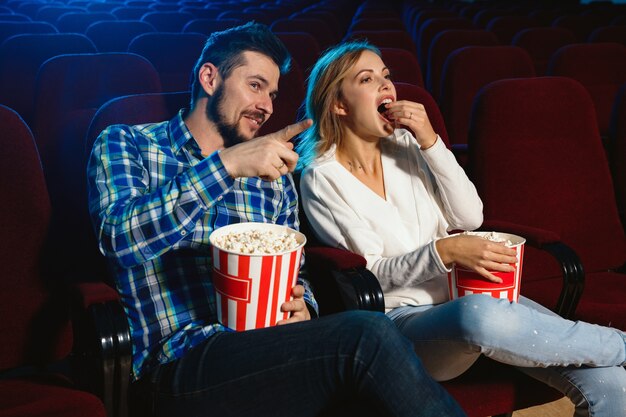 映画館で映画を見ている魅力的な若いカップル