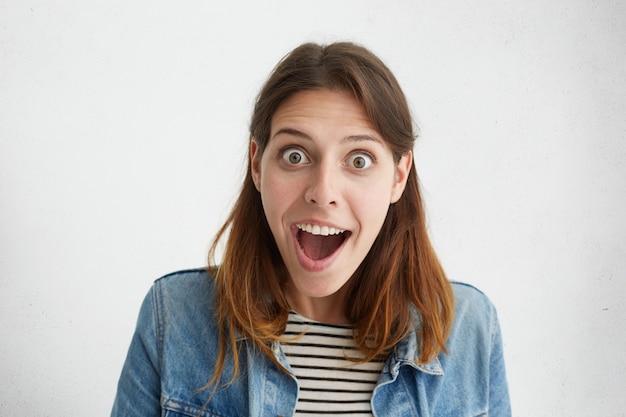 Free photo attractive young female looking at camera in shock and surprise