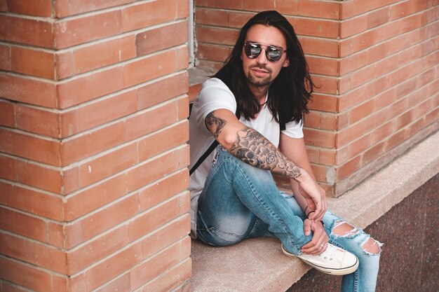 Attractive young man wearing sunglasses with tattoos